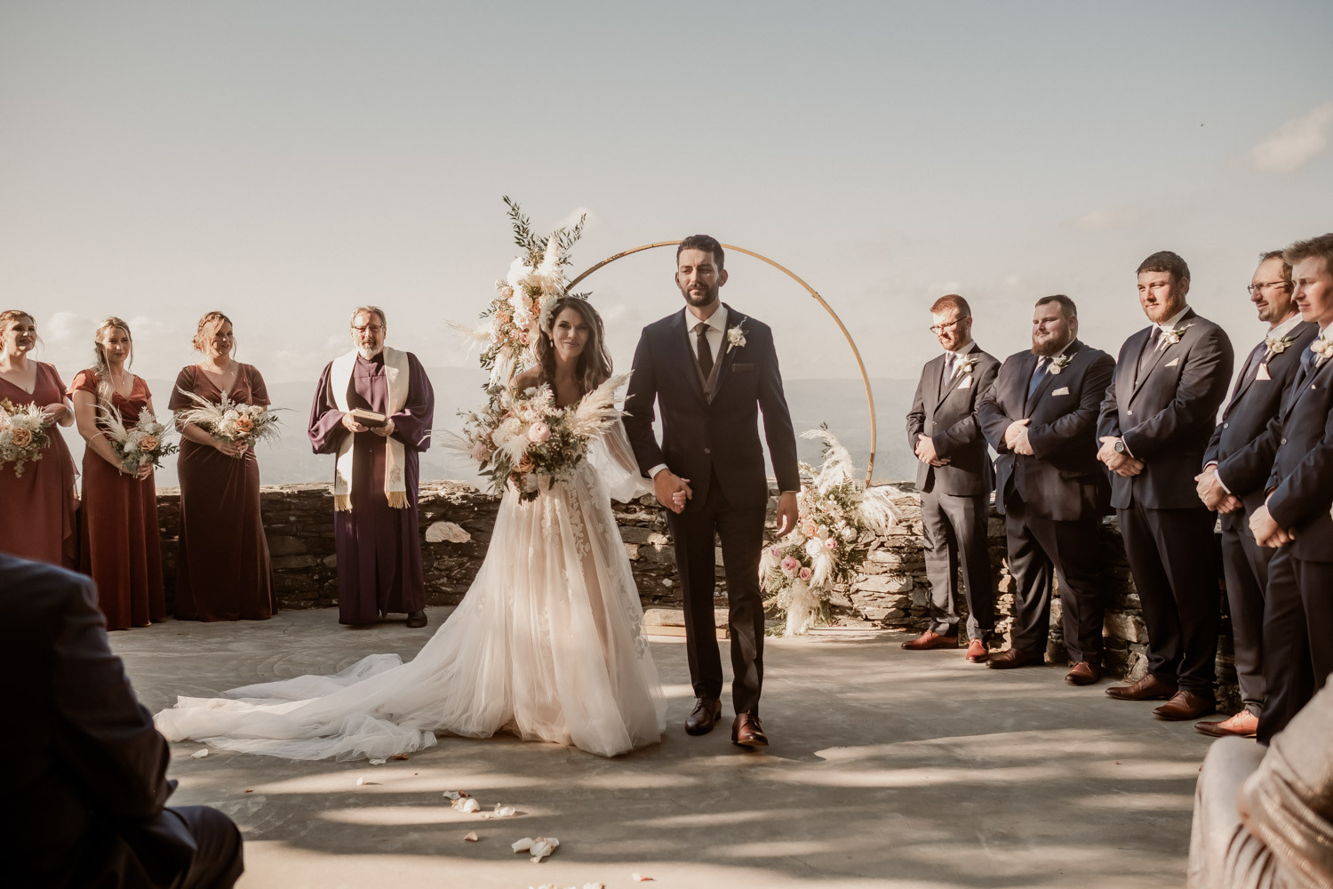 couple getting married overlooking the mountains with flowers and archway