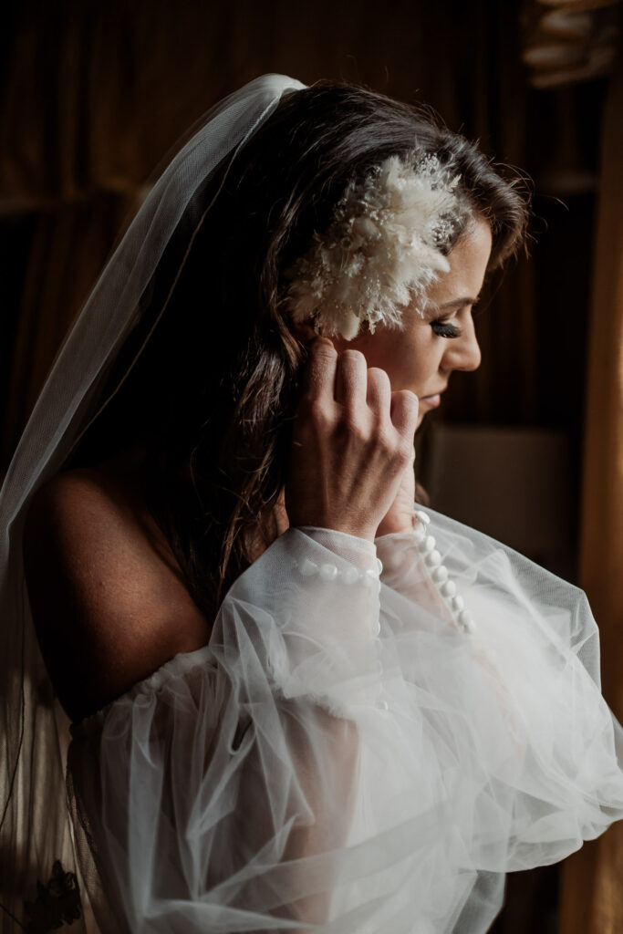 Bride getting ready in luxurious bridal suite with silk drapes and elegant decor.