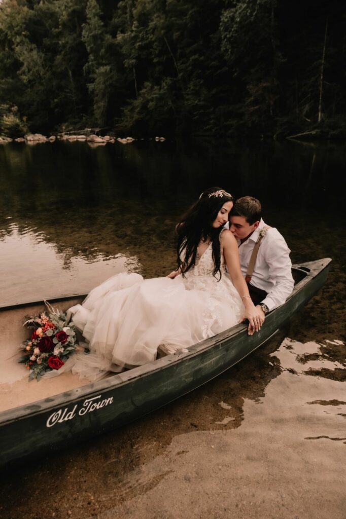 Romantic canoe adventure: Bride and groom paddling together in the middle of the lake at Brown Mountain Beach Resort.