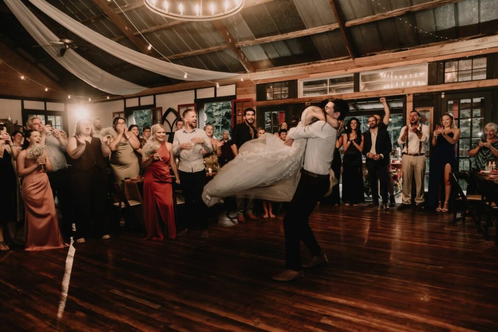 Epic choreographed first dance featuring spins, dips, and lifts at a fairytale riverside wedding