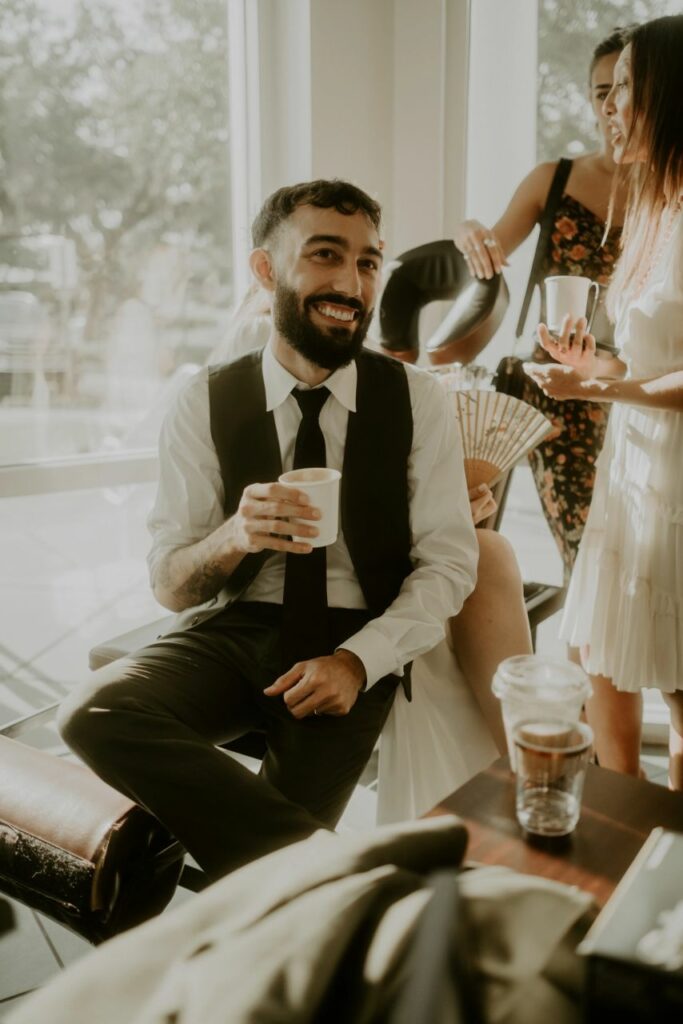 groom drinking coffee from coffee bar at weding reception