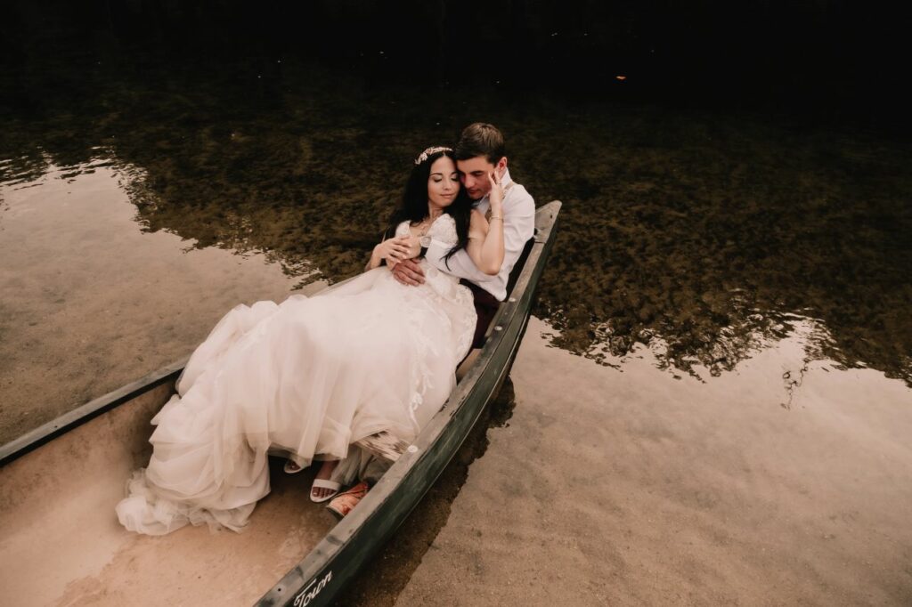 bride and groom embracing in canoe on wilson creek at Brown Mountain Beach Resort