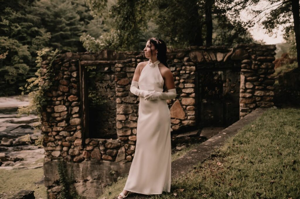 bride posing in front of stone ruins at Brown Mountain Beach Resort