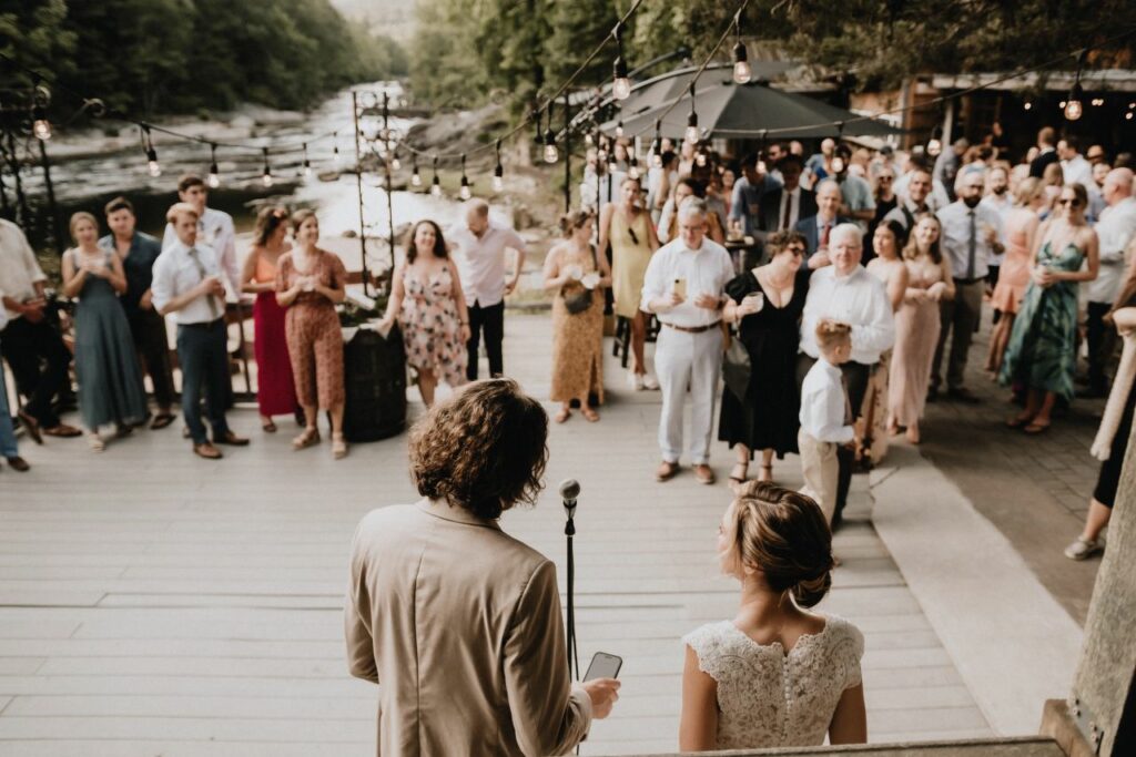 bride and groom giving speeches on deck overlooking the river at Brown Mountain Beach Resort