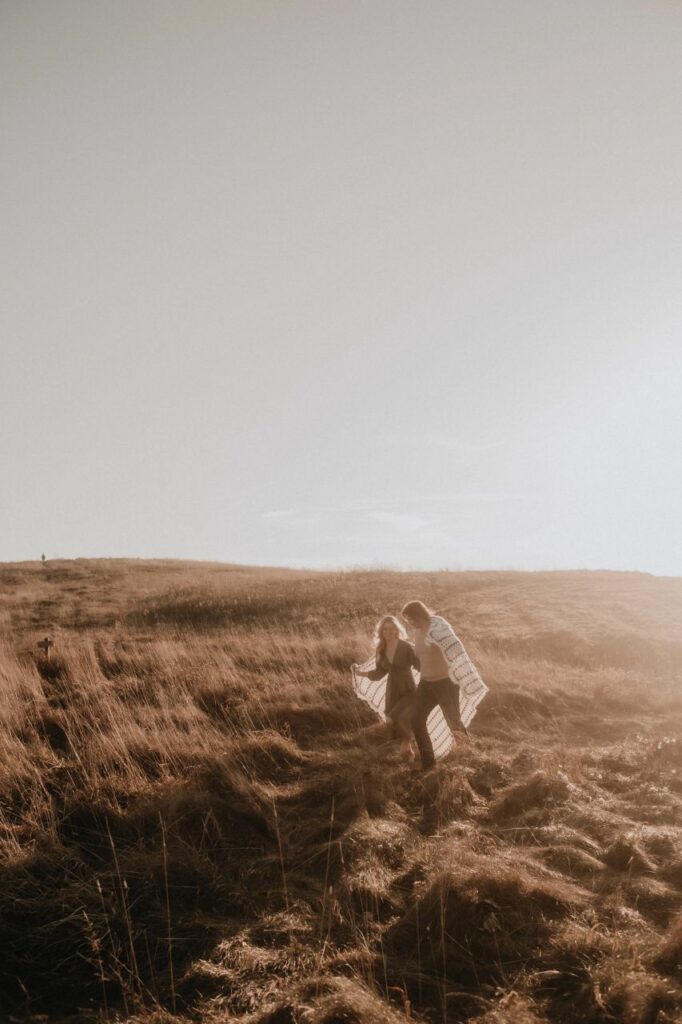 couple frolicking at their Max Patch engagement photos