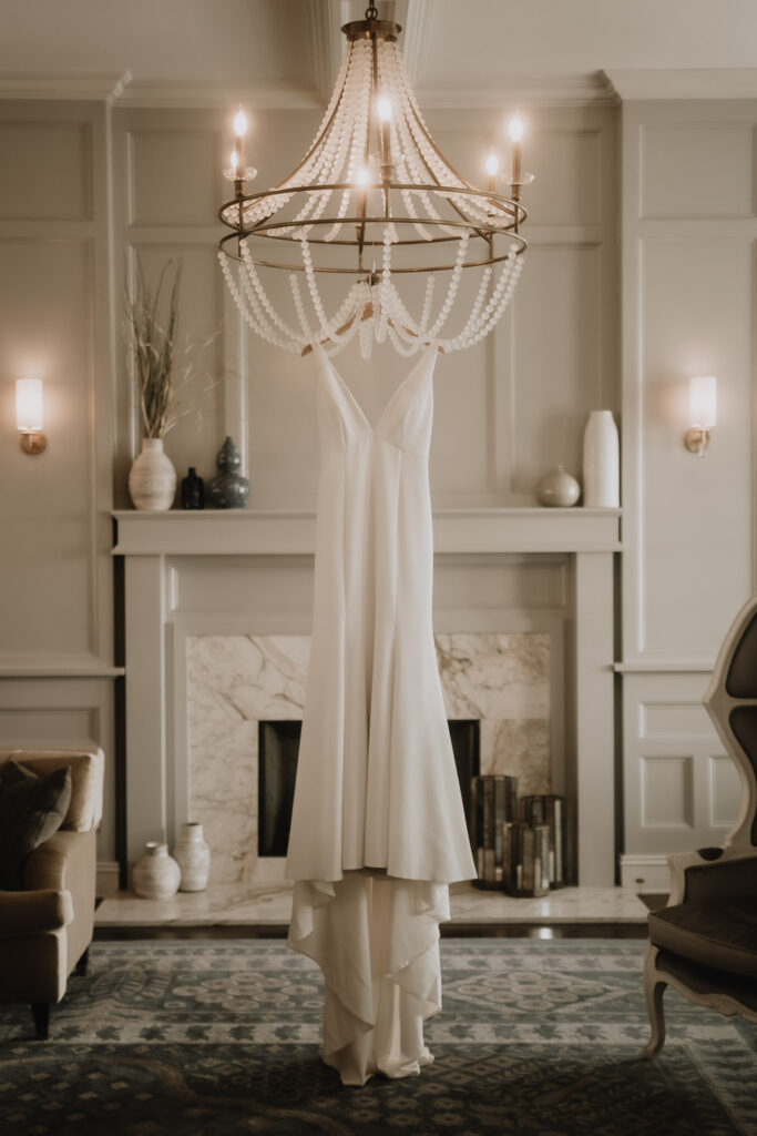 brides dress hanging from chandelier at Belleview Inn Wedding